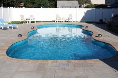 Example of a large beach style pool design in New York