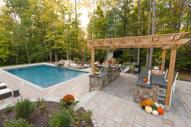 Example of a large classic backyard concrete paver and rectangular pool fountain design in Richmond
