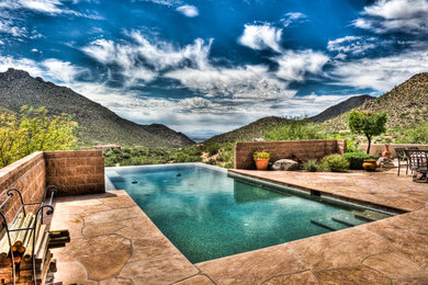Стильный дизайн: прямоугольный бассейн-инфинити среднего размера на заднем дворе в стиле фьюжн с джакузи и покрытием из каменной брусчатки - последний тренд
