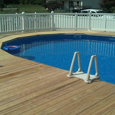 Pool - mid-sized traditional backyard round aboveground pool idea in Other with decking