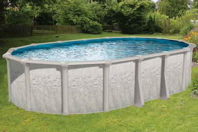 На фото: большой наземный бассейн произвольной формы на заднем дворе в морском стиле с