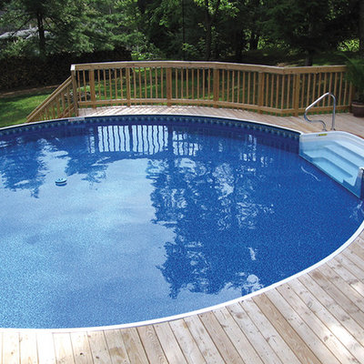 Example of a mid-sized classic backyard round pool design in Other with decking