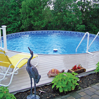 Example of a mid-sized classic backyard custom-shaped aboveground pool design in Other with decking
