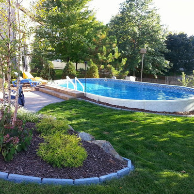 Pool - mid-sized traditional backyard custom-shaped aboveground pool idea in Other