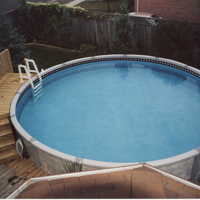 Pool - mid-sized traditional backyard round aboveground pool idea in Toronto with decking