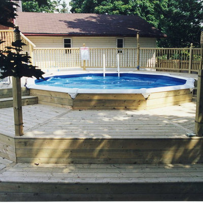 Inspiration for a mid-sized timeless backyard round aboveground pool remodel in Toronto with decking