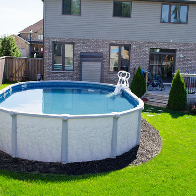 Inspiration for a mid-sized timeless backyard round aboveground pool remodel in Toronto