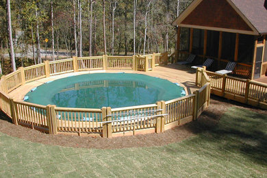 Large elegant backyard round lap pool photo in New York with decking