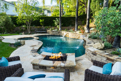 Ejemplo de piscina rústica a medida en patio trasero con adoquines de piedra natural