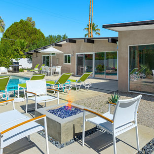 Imagen de piscina alargada, vintage, grande, rectangular, en patio trasero, con losas de hormigón