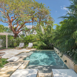 Esempio di una piccola piscina monocorsia tropicale personalizzata dietro casa con fontane e piastrelle