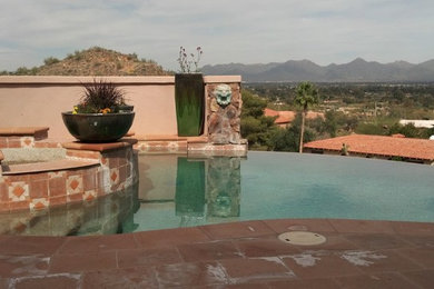 Inspiration for a mid-sized timeless backyard custom-shaped infinity hot tub remodel in Phoenix