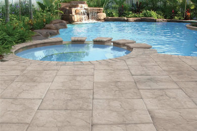 Example of a mid-sized island style backyard stamped concrete and custom-shaped lap pool fountain design in Miami