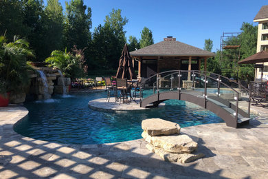 Example of a large beach style backyard stone and custom-shaped natural pool house design in Columbus