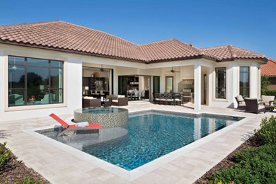 Example of a mid-sized transitional backyard tile and rectangular hot tub design in Miami
