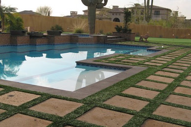 Ejemplo de casa de la piscina y piscina mediterránea grande a medida en patio trasero con adoquines de piedra natural