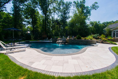 Mid-sized minimalist backyard stone and custom-shaped hot tub photo in New York