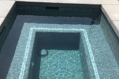 Mid-sized island style backyard concrete and custom-shaped lap hot tub photo in Orange County
