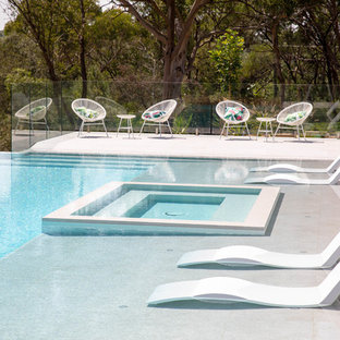 Inspiration for a contemporary backyard rectangular infinity pool in Newcastle - Maitland with a hot tub.
