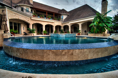 Inspiration for a large contemporary backyard stone and custom-shaped infinity pool fountain remodel in Austin