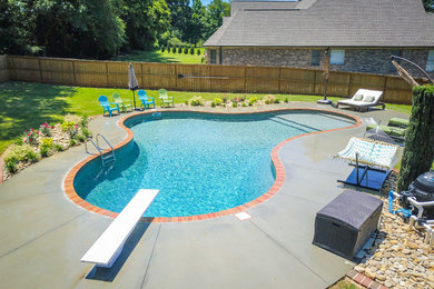 На фото: бассейн среднего размера, произвольной формы на заднем дворе