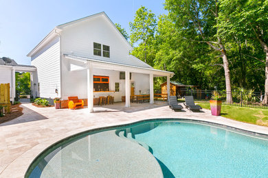 Modelo de casa de la piscina y piscina alargada actual de tamaño medio tipo riñón en patio trasero