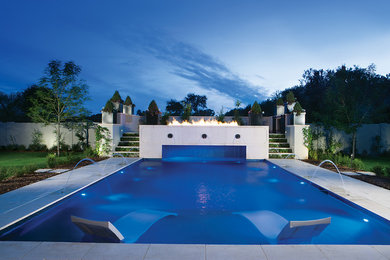Inspiration för mellanstora moderna rektangulär pooler på baksidan av huset, med naturstensplattor