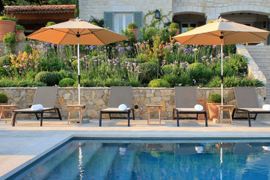 Modelo de piscina infinita mediterránea rectangular con adoquines de piedra natural