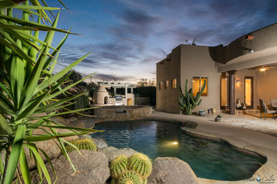 フェニックスにある中くらいなサンタフェスタイルのおしゃれな裏庭プールの写真