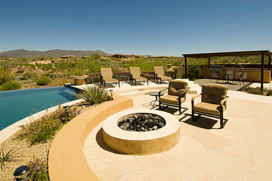 Ejemplo de piscina infinita de estilo americano grande a medida en patio trasero con adoquines de piedra natural