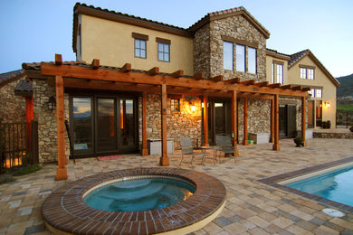 Large elegant backyard stone and rectangular lap hot tub photo in Other