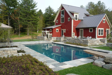 Foto de piscina tradicional grande rectangular en patio trasero con adoquines de piedra natural