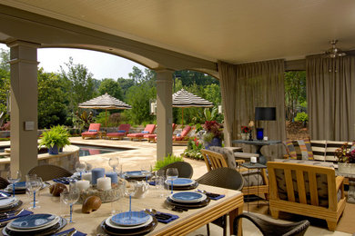 Ejemplo de casa de la piscina y piscina alargada tradicional grande rectangular en patio trasero con adoquines de piedra natural