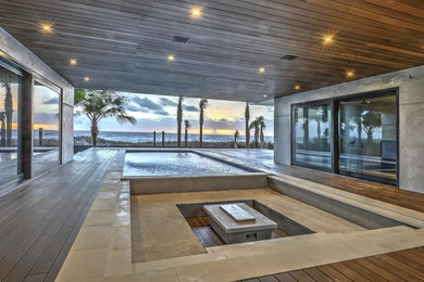 Ejemplo de piscina infinita minimalista grande interior y rectangular con adoquines de hormigón