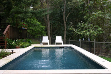 Mid-sized elegant backyard stone and rectangular lap pool fountain photo in Austin