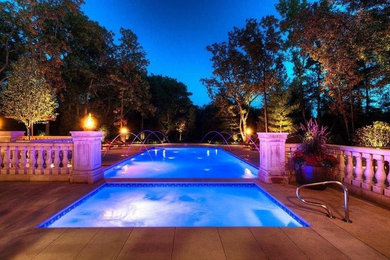 Photo of a large contemporary back rectangular natural swimming pool in Chicago with a water feature.