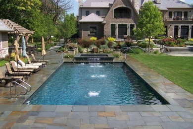 Modelo de piscina con fuente tradicional de tamaño medio rectangular en patio trasero