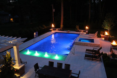 Cette image montre une grande piscine arrière traditionnelle rectangle avec un point d'eau.