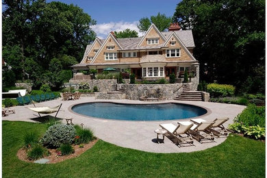 Large elegant backyard concrete paver and kidney-shaped pool fountain photo in New York
