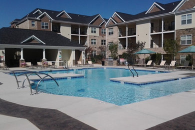 Photo of a large world-inspired courtyard custom shaped swimming pool in Charlotte with a water feature and decking.