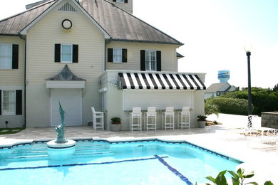 Inspiration for a large coastal back rectangular lengths swimming pool in Other with a pool house and tiled flooring.