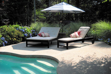 Mid-sized elegant backyard concrete and custom-shaped pool photo in Providence