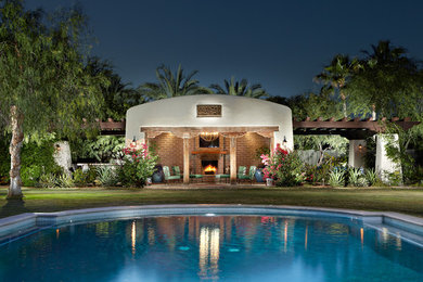 Mid-sized southwest backyard stone and custom-shaped aboveground pool house photo in Phoenix