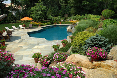 Idéer för en stor modern pool på baksidan av huset, med spabad och naturstensplattor