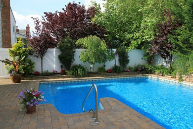 Mid-sized backyard stone and l-shaped natural pool photo in New York