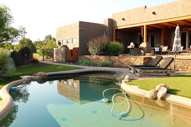 Large trendy backyard brick and custom-shaped lap pool photo in Phoenix