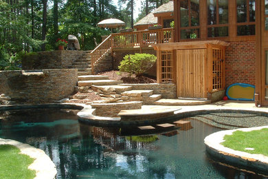 Imagen de piscinas y jacuzzis elevados de estilo americano de tamaño medio a medida en patio trasero con adoquines de piedra natural
