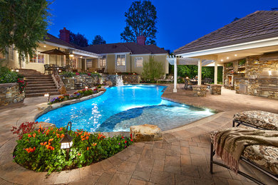 Example of a large transitional backyard concrete paver and custom-shaped hot tub design in Los Angeles