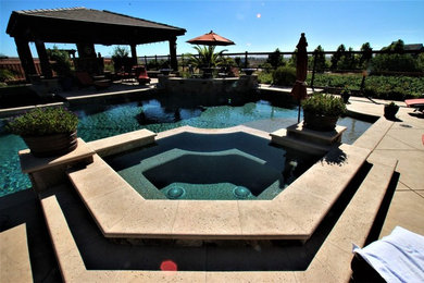 Design ideas for a large contemporary back custom shaped lengths hot tub in San Francisco with concrete paving.
