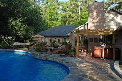 Foto de piscinas y jacuzzis alargados clásicos de tamaño medio tipo riñón en patio trasero con adoquines de piedra natural